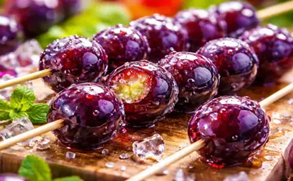 Espetinho de uvas roxas brilhantes (Uva Vitória) cobertas com calda de açúcar crocante, conhecido como Uva do Amor ou Tanghulu.